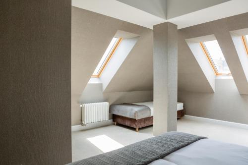a attic bedroom with a bed and skylights at Browar Hevelius Apartments by Grand Apartments in Gdańsk