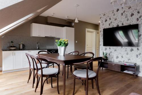 a kitchen and dining room with a table and chairs at Browar Hevelius Apartments by Grand Apartments in Gdańsk