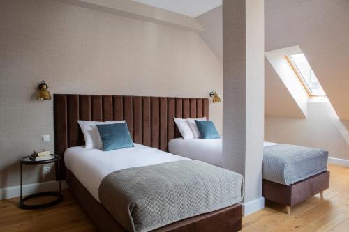 a bedroom with two beds and a staircase at Browar Hevelius Apartments by Grand Apartments in Gdańsk