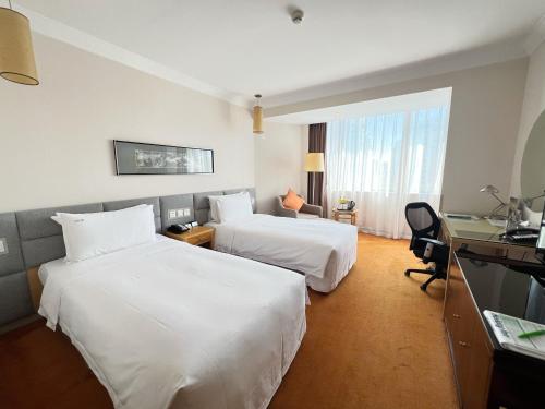 a hotel room with two beds and a desk at Holiday Inn Temple Of Heaven Beijing by IHG in Beijing