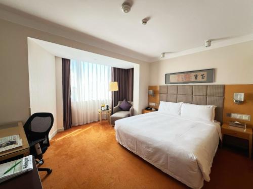 a hotel room with a white bed and a chair at Holiday Inn Temple Of Heaven Beijing by IHG in Beijing