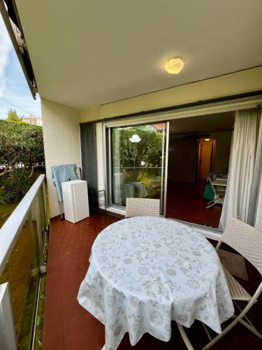 d'un balcon avec une table et des chaises blanches ainsi qu'une fenêtre. dans l'établissement Parc Montfleury, à Cannes