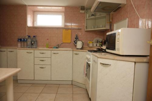 a kitchen with white cabinets and a microwave at Guest House Linas in Alytus