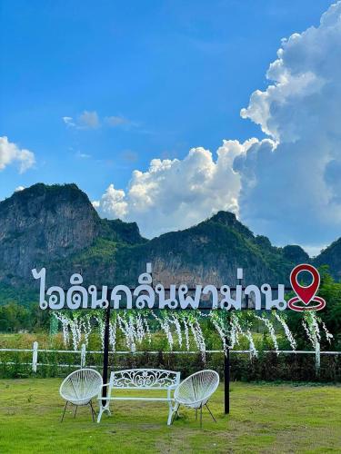 two chairs and a bench in front of a sign at Idin Klin Pha Man in Ban Nong Pla Siu