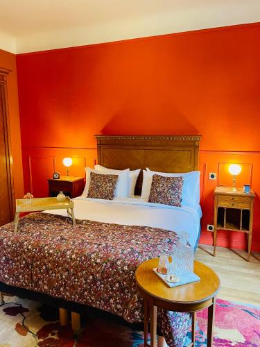 a bedroom with a bed and a red wall at La Maison au toit vert in Espalion