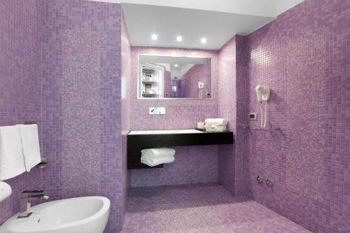 a purple bathroom with a sink and a mirror at Magi House Relais in Sorrento