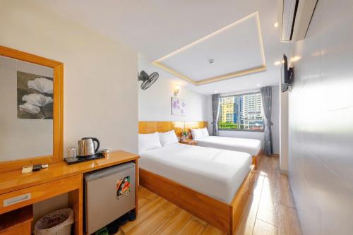 a hotel room with two beds and a window at Hằng Nga Hotel in Nha Trang
