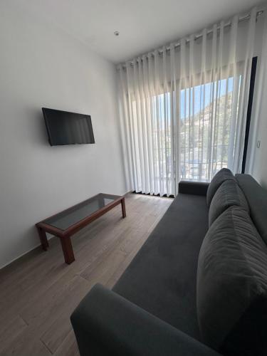a living room with a couch and a tv at Villa Thomas in Dhërmi