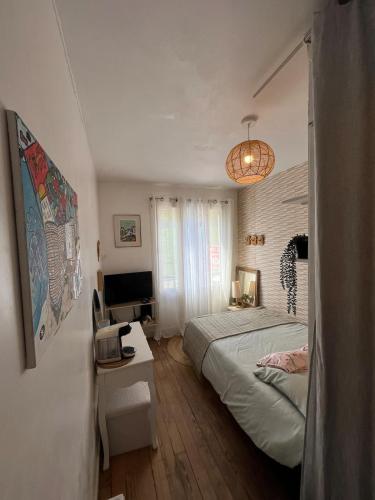 une chambre avec un lit et un bureau avec un ordinateur dans l'établissement Petit cocoon face au Château de Caen, à Caen