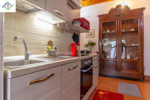 a kitchen with a sink and a wooden cabinet at Villa Nobile Oasi Lucca Appartamento Terrazza in Porcari