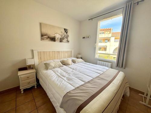 une chambre avec un grand lit et une fenêtre dans l'établissement Appartement avec terrasse privée, climatisé, à Six-Fours-les-Plages