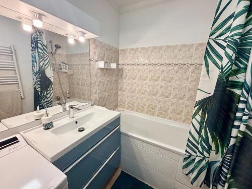 une salle de bain avec un lavabo et une baignoire et un lavabo dans l'établissement Appartement avec terrasse privée, climatisé, à Six-Fours-les-Plages