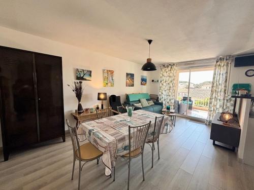un salon avec une table, des chaises et un canapé dans l'établissement Appartement avec terrasse privée, climatisé, à Six-Fours-les-Plages