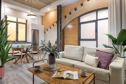 ein Wohnzimmer mit einer Couch und einem Tisch in der Unterkunft Suites Maestranza - Herrería by Magno Apartments in Sevilla