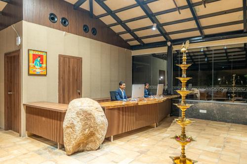 a man sitting at a bar in a restaurant at Serene Resort Hyderabad in Shamshabad