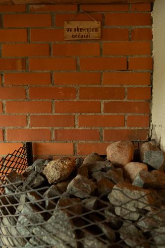 a brick wall with a no engagement required sign next to rocks at Viesu nams ''Laukezers'' in Vilciņi