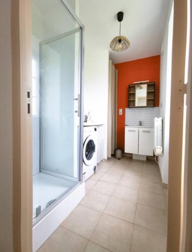 a bathroom with a shower and a washing machine at Duplex 2 chambres avec jardin 15 mn de Bayonne à Urt in Urt