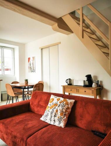 a red couch in a living room with a table at Duplex 2 chambres avec jardin 15 mn de Bayonne à Urt in Urt
