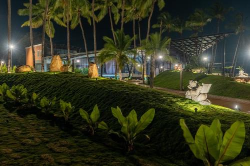 a park at night with palm trees and a building at Serene Resort Hyderabad in Shamshabad