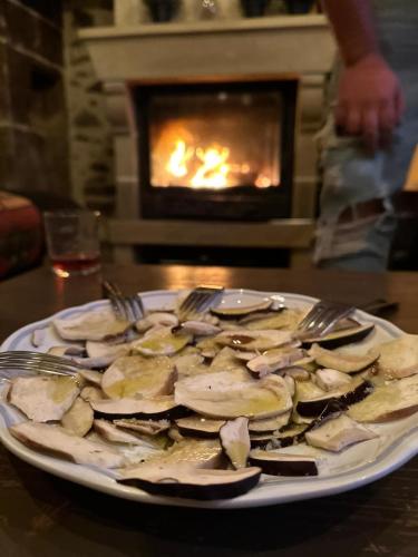 une assiette de nourriture sur une table devant une cheminée dans l'établissement Le Battut, à Beaulieu-sur-Dordogne