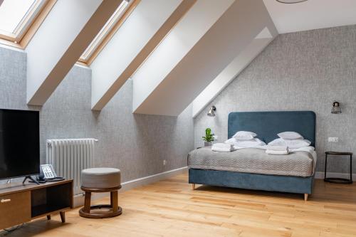 a bedroom with a blue bed in a attic at Browar Hevelius Apartments by Grand Apartments in Gdańsk