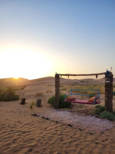 a swing in the sand in the desert at Camp Mbark authentic in Mhamid