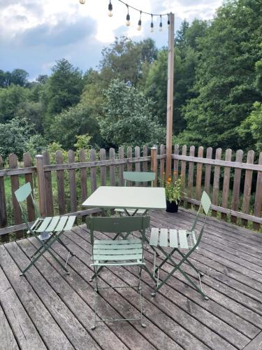 a picnic table and chairs on a wooden deck at Pressoir en Normandie in Les Isles-Bardel