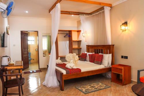 a bedroom with a bed with a canopy at Kambua Resort in Libwezi
