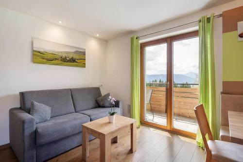 a living room with a couch and a large window at Waldheim in Verano