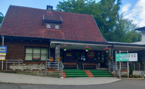a house with a red roof with a green porch at Mátraházai Üdülőház in Mátraháza