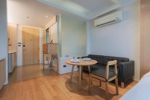 a living room with a table and a couch at Balcony Seaside Sriracha Hotel & Serviced Apartments in Si Racha