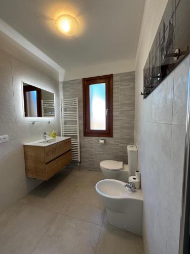 a bathroom with a sink and a toilet and a sink at Casabianca Resort Villas in Lignano Sabbiadoro