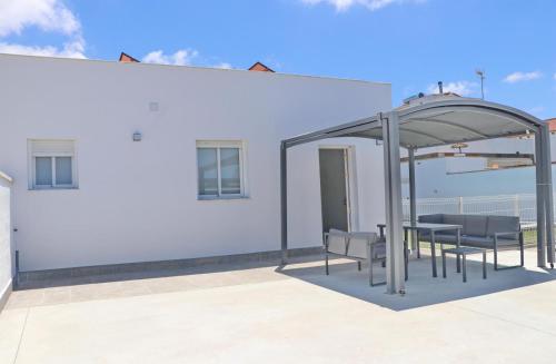 a table and chairs under a pavilion on a white building at Chalet Ruperto III in Conil de la Frontera