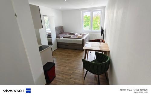 a small room with a table and a bed at Moderne Apartments mit Klima, perfekter Anbindung ins Zentrum und kostenlose Parkplätze! in Vienna