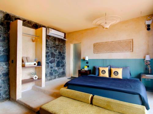 a bedroom with a blue bed and a couch at The Hosteller Bhandardara in Bhandardara 
