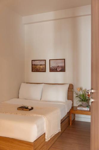 a bedroom with a bed and a table at Otis Soho Saigon Balcony Apartment in Ho Chi Minh City