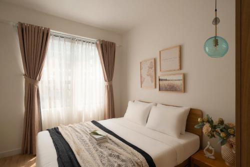 a bedroom with a bed and a window at Otis Soho Saigon Balcony Apartment in Ho Chi Minh City
