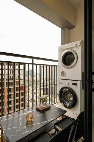 a balcony with a table and a washing machine at Otis Soho Saigon Balcony Apartment in Ho Chi Minh City