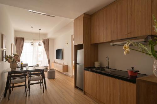 a kitchen with wooden cabinets and a table with chairs at Otis Soho Saigon Balcony Apartment in Ho Chi Minh City