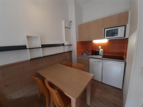 une petite cuisine avec une table et un micro-ondes dans l'établissement Appartement 2 Pièces au Centre de La Tania, 4 Pers, Balcon, Proche Remontée Mécanique et Piscine - FR-1-513-94, à Courchevel