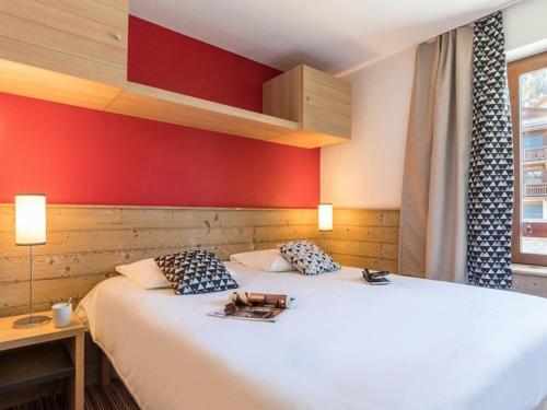 - une chambre dotée d'un lit avec un mur rouge dans l'établissement Appartement 2 Pièces au Centre de La Tania, 4 Pers, Balcon, Proche Remontée Mécanique et Piscine - FR-1-513-94, à Courchevel