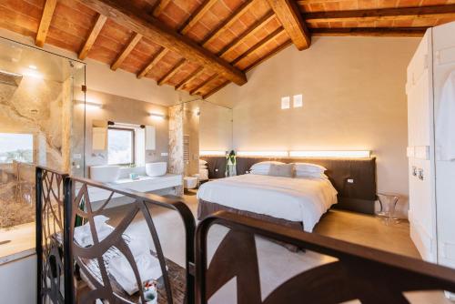 a bedroom with a bed and a bathroom at Torre di Baratti Bio Resort in Populonia