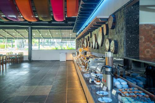 a restaurant with a counter with dishes on the wall at Serene Resort Hyderabad in Shamshabad