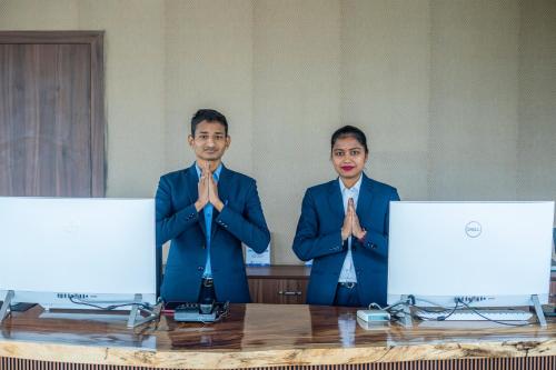 two men in suits are standing at a table with their hands in front at Serene Resort Hyderabad in Shamshabad