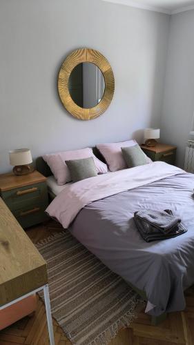 a bedroom with a bed with a mirror on the wall at Vintage in Đakovo