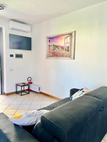 a living room with a couch and a window at house prua a step from the lake in Bellano