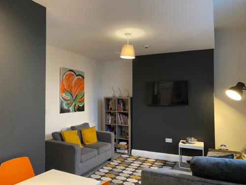 a living room with a couch and a tv at Mia's Place Chester in Chester