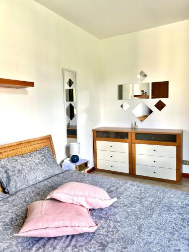 a bedroom with a large bed and a dresser at house prua a step from the lake in Bellano
