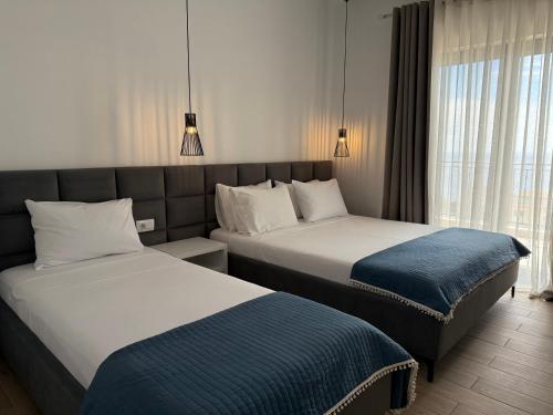 a hotel room with two beds and a window at Villa Thomas in Dhërmi