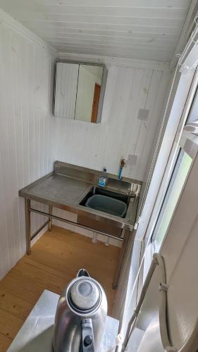 a small bathroom with a sink and a mirror at Glengoulandie Glamping in White Bridge